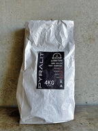 White bag of Pyralit charcoal with a black label on a concrete floor.