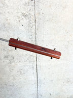 Wooden stick with metal components on a concrete surface
